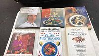 Overview of the 6 cookbooks arranged on black surface showing their cover titles and images