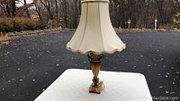 Full view of the vintage table lamp showing the lamp shade and base with amber color and gold trim.