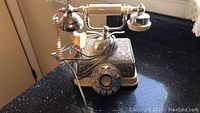 Front angle view showing ornate detailed metal base and rotary dial.