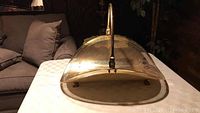 Front view of the brass log holder showing the curved design and handle