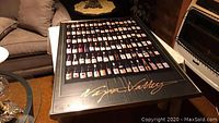 Framed poster showing various labeled wine bottles and 'Napa Valley' written in gold script below.