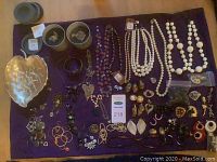 Top-down layout showing assorted jewelry pieces on purple cloth