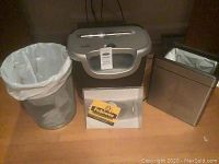 Overall view of shredder with two bins placed on floor, showing sizes and presence of liners.