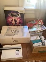 Overhead view of boxed Nintendo Wii console, DDR Hottest Party 3 box, controller box and cardboard box of accessories