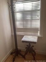 Full view of coat tree and side table positioned by a window, showing overall size and appearance.
