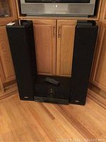 Two Energy floor-standing tower speakers, Energy center speaker and Mitsubishi XL-C1 stereo component under TV stand