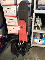 Full shot of the longboard, shoes, and some surrounding items.