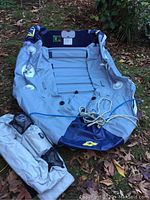 Partially inflated Zodiac C250 boat laid out on grass with life jackets visible