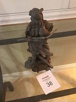 Side angle view of the detailed pewter fur trapper statue on display showing full figure and bow.