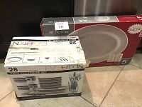 Photo showing boxed 28-piece Evolution white with blue trimmed dish set, service for 4