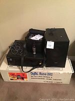 Full setup of Sony Digital Audio 2002 system components on original box including receiver, speaker, carrying case with manuals, a bottle, and cables.