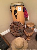 Large conga next to mini conga, frame drum and goblet drum in corner