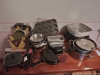 Overview of entire lot with skillets, waffle maker, pressure cooker, pans, boards and racks