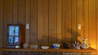 Full view of all items on a mantel including the clock, vases, candle holders, figurine, and bowl.
