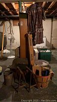 Full lot view showing items including bushel basket, metal bucket, copper boiler, projection screen, burlap bags, Keds sneakers, grinder, wooden box, saw horses.