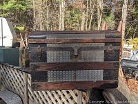 Front view of the dome-top trunk showing metal and wood construction with central latch and side latches.