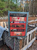 Front and side view of the vintage red mechanics tool box showing decals, lock hasp, two shelf compartments, and swivel caster wheels.