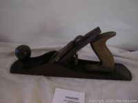 Side view of vintage Stanley Bailey No. 5 block plane showing metal body, wooden front knob and rear handle with surface rust and wear.