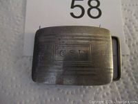 Front view of vintage sterling silver belt buckle showing worn engraved initials 'CSP' and horizontal line texture.