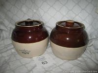 Two vintage ceramic bean pots side by side, both are 2 quart size, brown glazed top half and beige bottom half, one pot lid shows a chip on the rim.