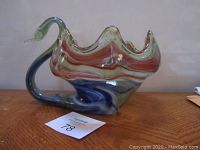 Front and top angle showing the multicolored swan-shaped art glass vase with wavy top edges and smooth curved neck and head.