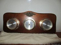 Front view of the vintage Springfield Instrument Co. wooden plaque with thermometer, barometer, and humidity meter featuring brass casings and eagle emblem.