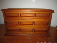Front view of the vintage cedar jewelry box showing three drawers with carved wooden pulls and solid rectangular shape