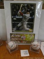 Two autographed baseballs displayed in clear acrylic cases with a framed USPS First Day Issue featuring Boston Red Sox team and Jacoby Ellsbury.