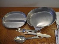Photo showing the oval metal tray, divided metal plate, and complete set of utensils (fork, knife, spoon)