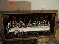 Full view of The Last Supper painting on black velvet with carved wood frame. Shows entire artwork and border.
