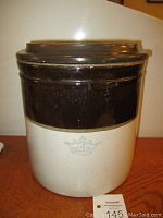 Full front view of the crock showing two-tone beige and brown glaze, crown 4 marking and lid on top.
