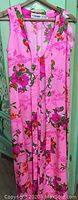 Full frontal photo of the pink floral dress hanging, showing the sleeveless design, V-neckline and floral pattern.