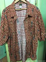 Full view of vintage Teva men's shirt showing front, short sleeves, and collar against green background.
