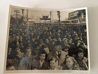 Photo showing a large crowd of people gathered outside a TTC subway station with visible urban background, telegraph poles, and signs.