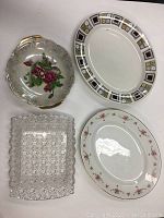 Four vintage serving dishes including a Kathie Winkle floral dish with gold trim, an oval porcelain dish with floral border, a clear textured rectangular glass dish, and an oval porcelain dish with geometric border.