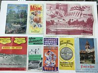 Seven vintage Florida tourism brochures and pamphlets laid out on a white surface. Items include Cypress Gardens guide, Miami guide, Daytona Beach pamphlets, Jacksonville brochure, Webb's Circus flyer, and historic St. Augustine poster.