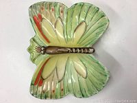 Full view of the ceramic butterfly-shaped dish viewed from above showing colorful wings and the brown body.