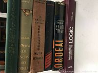 Front view of six vintage hardcover books arranged vertically, showing the spines with titles and authors visible.