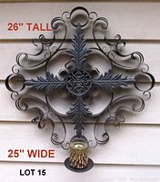 Full frontal view of the large black metal wall hanging with Celtic design, showing dimensions and bottom holder for candle or planter.