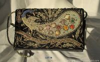 Front view of vintage black fabric purse with embroidered gold foliage and colorful beaded peacock.