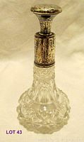 Full view of the vintage glass perfume bottle with sterling silver cap and collar, showing intricate cut glass design and hammered silver.