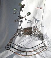 Full view of the metal wireframe rocking reindeer showing its shape, rocking base, and antlers with leaf decorations.