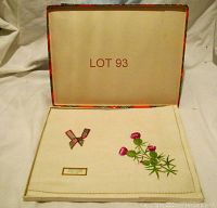 Tray cloth folded neatly inside original box, showing embroidered Scottish thistle design on cream linen with a plaid ribbon detail and label reading 'PURE IRISH LINEN MADE IN IRELAND'.