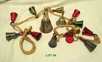 Full view of the long rope string with colorful small brass bells and two larger silver-tone bells positioned on white background.