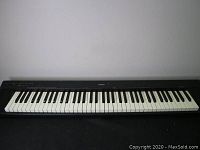Full front view of Yamaha NP-30 keyboard showing all 88 keys and black casing.