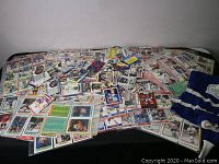 Wide view of many loose and binder-inserted hockey sports cards spread on a table