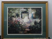 Full front view of framed art showing garden scene with white door and flowers, surrounded by green mat and gold frame.