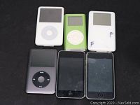 Top view of six iPods including classic, vintage, and touch models arranged on a dark surface