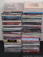 Stacks of CDs with visible artists including Jesse Cook, Glen Campbell, Doris Day, and others.