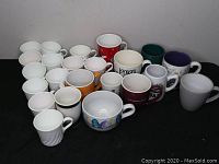 Overview of over 20 assorted coffee mugs arranged in rows showing various colors and designs.